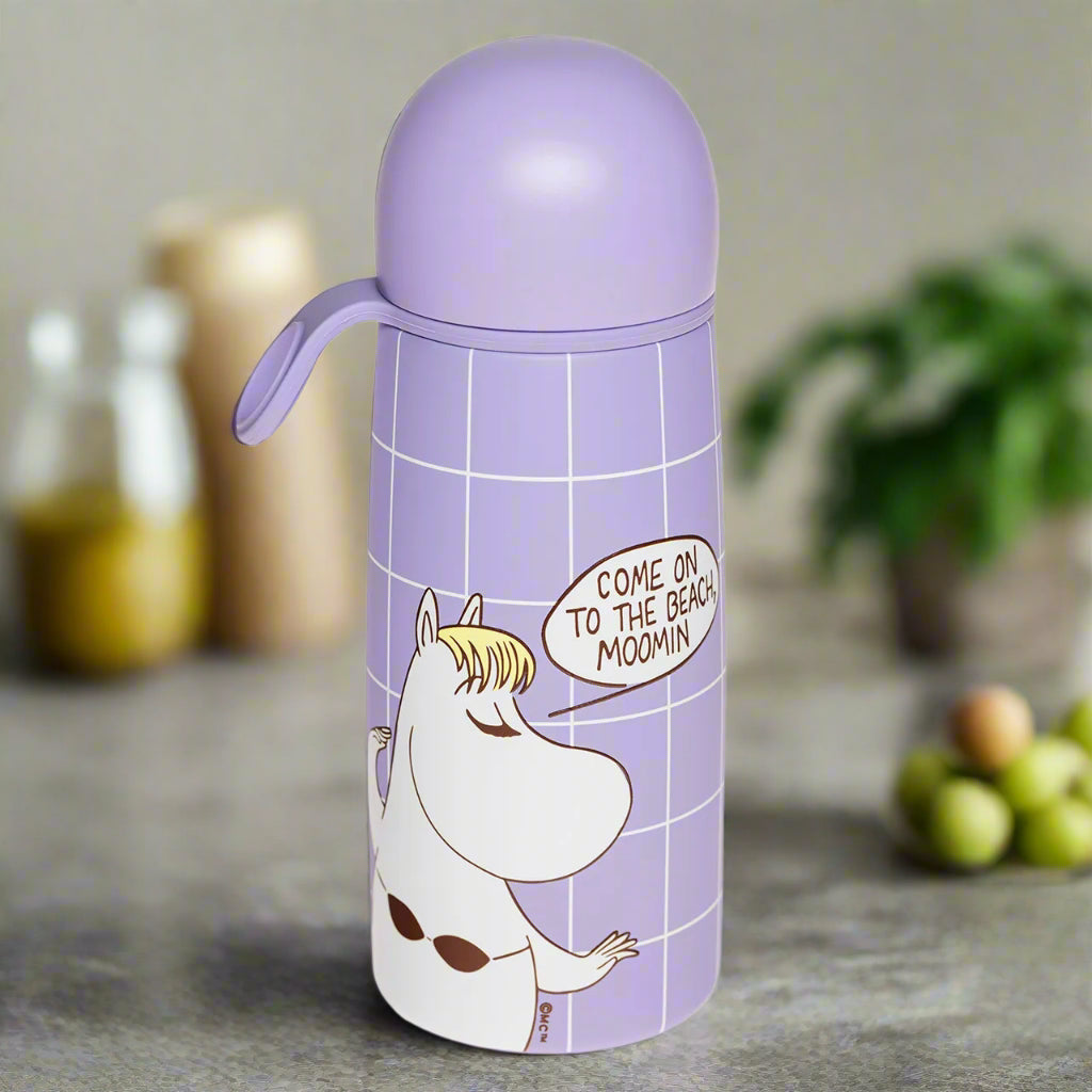 Purple water bottle with Moomin character and text on a white background
