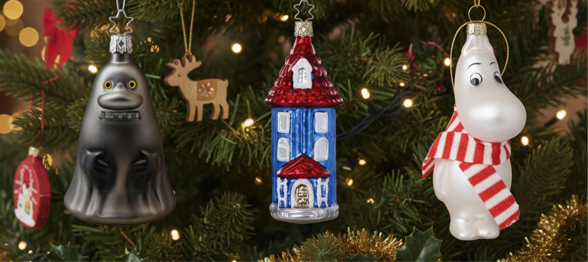 Decorative Christmas ornaments on a tree with lights and tinsel.